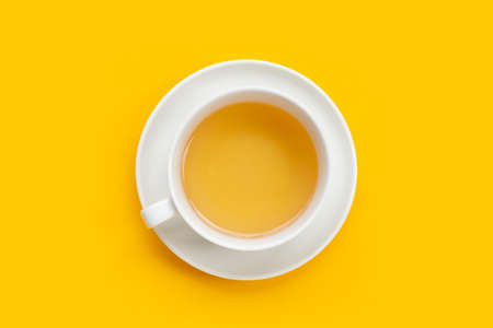 White cup of tea on yellow backgroundの写真素材