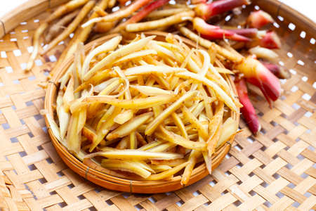 Sliced fingerroot in bamboo basket on white background.の写真素材