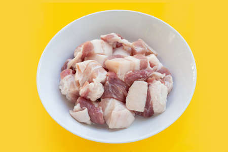 Cut streaky pork in white bowl on yellow background.の写真素材