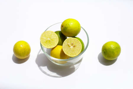 Fresh limes in glass bowl on white background.の写真素材