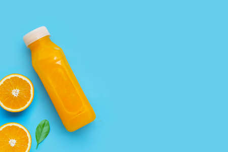 Orange juice in plastic bottle on blue background.の写真素材