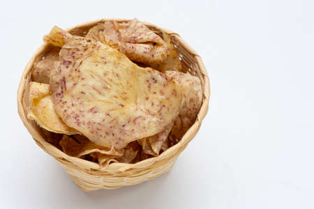 Crispy taro chips in bamboo basket on white background.の写真素材