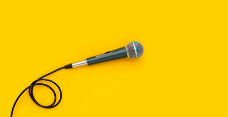 Microphone on yellow background. Top view