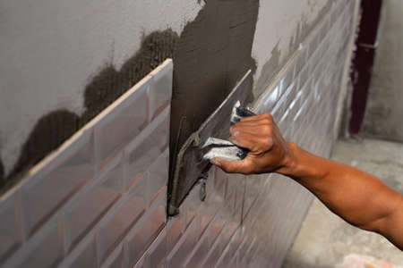 House renovation, Laying ceramic tiles on the wall.