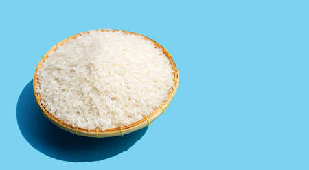 Raw rice in bamboo basket on blue background.の写真素材