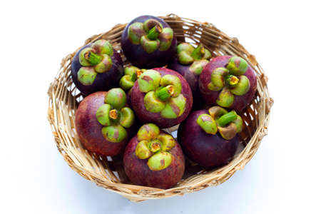 Mangosteen in bamboo basket on white background.の写真素材