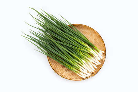 Spring onions in bamboo basket on white backgroundの写真素材