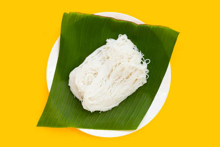 Rice noodles on banana leaf in white plate on yellow background.の写真素材