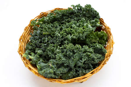 Kale leaves in bamboo basket on white background.の写真素材