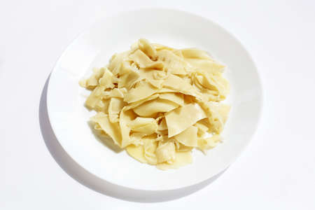 Preserved bamboo shoot slices in white plate on white background.の写真素材
