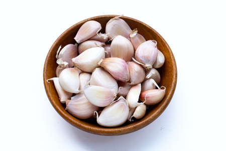 Garlic in wooden bowl on white backgroundの写真素材
