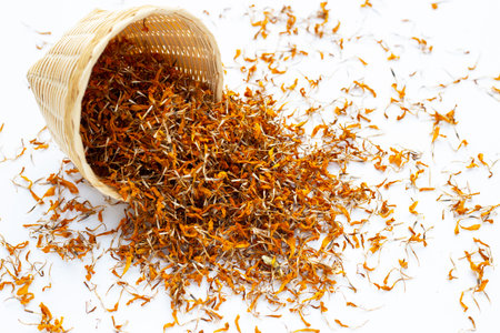 Dried marigold flower petals on white background. Flower herbal tea concept.の写真素材