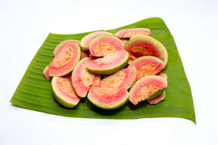 Fresh pink guava on banana leaf on white background.の写真素材