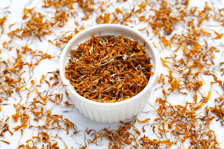 Dried marigold flower petals on white background. Flower herbal tea concept.の写真素材
