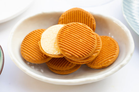 Custard cream sandwich biscuits on white background.の写真素材