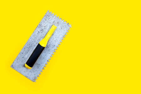 Old Notched Trowel on yellow background.の写真素材
