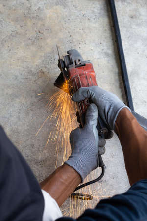 Close up, A man working with angle grinder. Iron gate repair