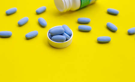 PrEP ( Pre-Exposure Prophylaxis) blue pills used to prevent HIV on yellow surfaceの写真素材