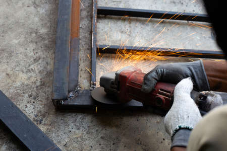 Close up, A man working with angle grinder. Iron gate repair
