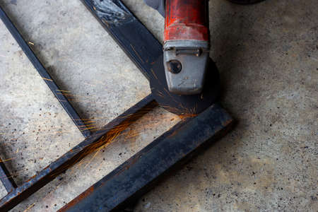 Close up, A man working with angle grinder. Iron gate repair