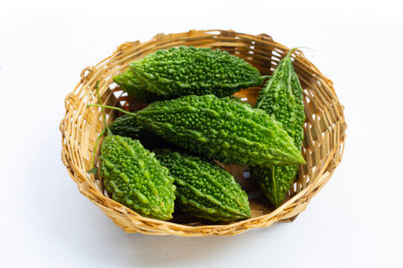 Bitter gourd in bamboo basket on white background.の写真素材