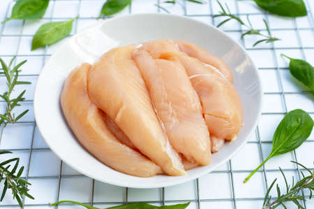 Raw chicken tenders with rosemary and sweet basilの写真素材