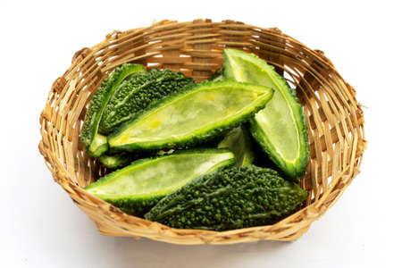 Bitter gourd in bamboo basket on white background.の写真素材