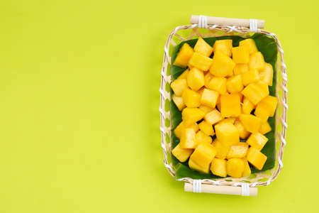 Tropical fruit, Mango cube slices in bamboo basket on green background.の写真素材