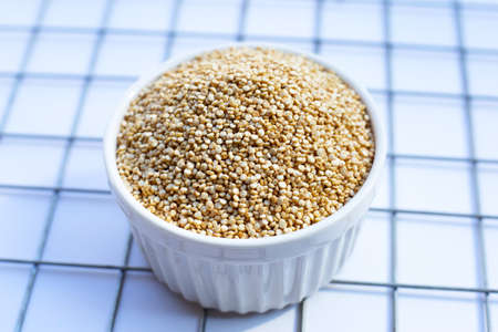 Organic Quinoa in cup on white background.