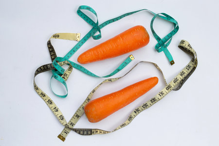 Carrot wrapped in measuring tapeの写真素材