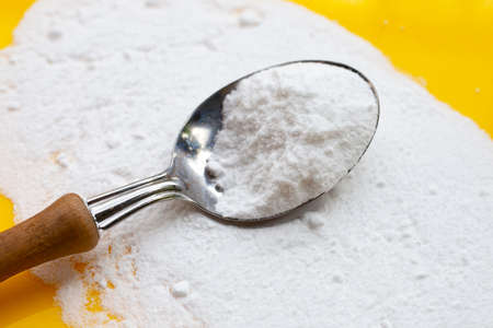 Baking soda on yellow background.の写真素材