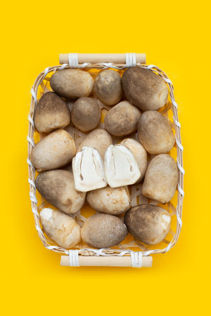 Straw mushroom in bamboo basket on yellow background.の写真素材