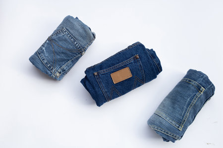 Rolled blue jeans on white backgroundの写真素材
