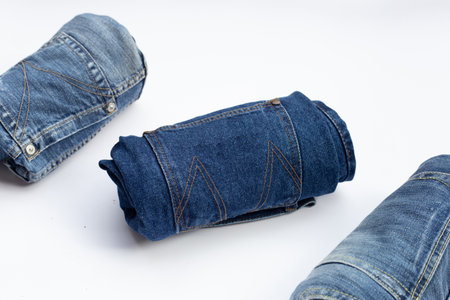 Rolled blue jeans on white backgroundの写真素材