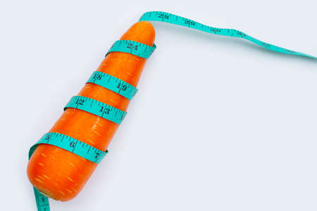 Carrot wrapped in measuring tapeの写真素材