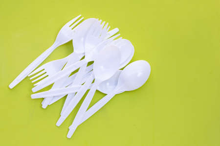 Plastic fork and spoon on green background.の写真素材