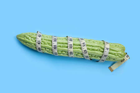 Bitter melon wrapped in measuring tapeの写真素材