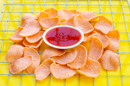 Prawn crackers on yellow background. Shrimp crispy rice snack