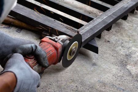 Close up, A man working with angle grinder. Iron gate repair