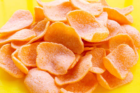 Prawn crackers on yellow background. Shrimp crispy rice snack