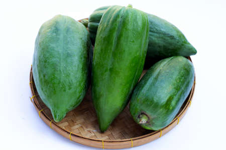 Green papaya in round bamboo basketの写真素材