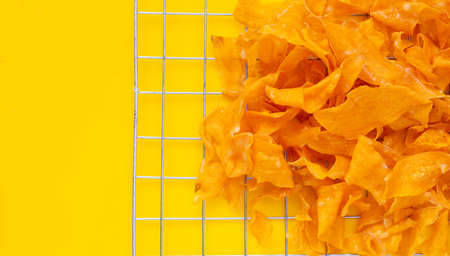 Sweet potato chips on yellow background.の写真素材