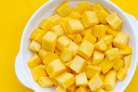 Tropical fruit, Mango cube slices in white bowl on yellow background.の写真素材