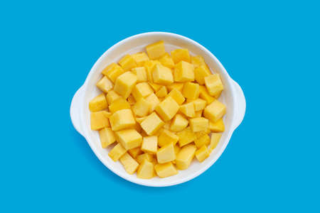 Tropical fruit, Mango cube slices in white bowl on blue background.の写真素材