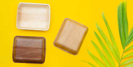 Betel palm leaf plates on yellow background.の写真素材