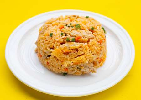 Fried rice in white plate on yellow background.の写真素材