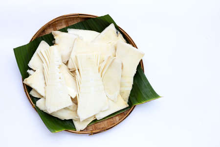 Sliced raw bamboo shoots in bamboo basket on white background.の写真素材
