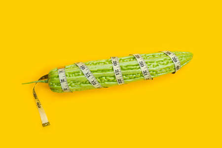 Bitter melon wrapped in measuring tapeの写真素材