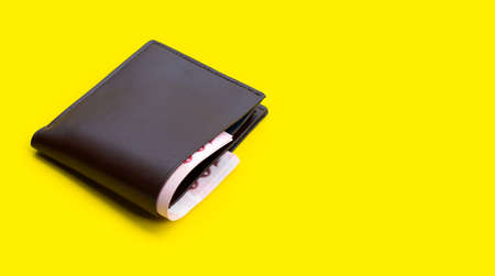Brown wallet on yellow background