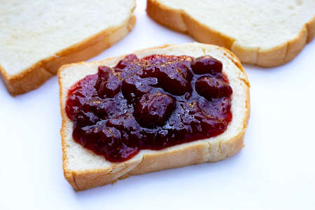 Bread with strawberry jam on white backgroundの写真素材